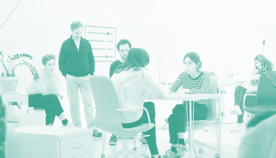 Picture of With Company giving a workshop, has a green duotone filter.